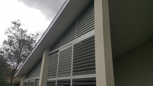 rivacy screen with sliding adjustable blades with a fixed blade above on a angle