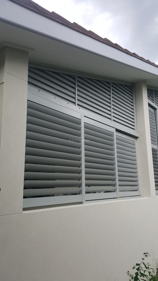 rivacy screen with sliding adjustable blades with a fixed blade above on a angle