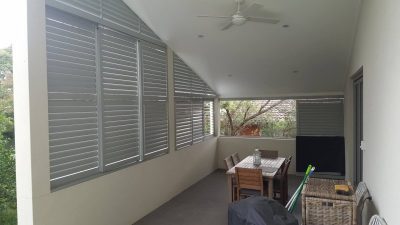 rivacy screen with sliding adjustable blades with a fixed blade above on a angle