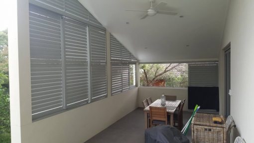 rivacy screen with sliding adjustable blades with a fixed blade above on a angle
