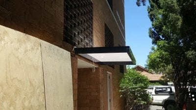 Slimline awning over a door way in to a block of units