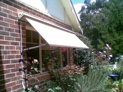 Pivot arm fabric awnings